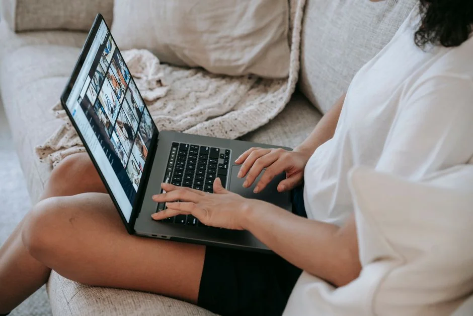Hands typing on a laptop with cryptocurrency charts and smartphone display in view, focusing on digital finance.